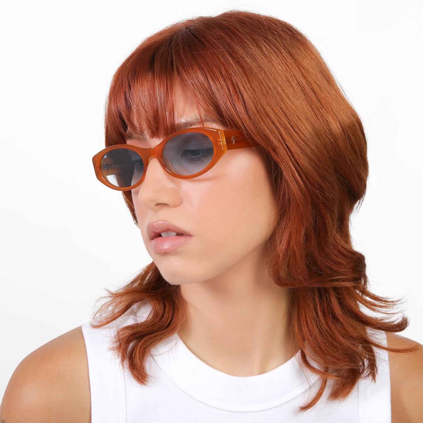 Model wearing Exumas Sunglasses in Tangerine with Blue Gradient lenses