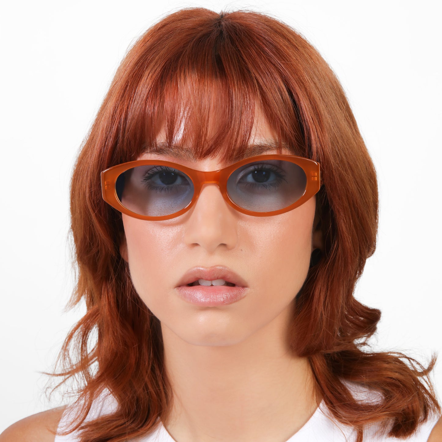 Another angle of model wearing Exumas Sunglasses in Tangerine with Blue Gradient lenses
