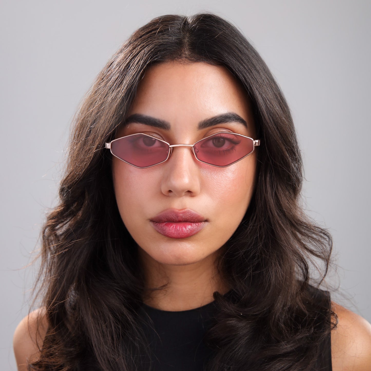 Brunette woman wearing Opa Sunglasses in Rose Gold Havana with Maroon See Through lenses