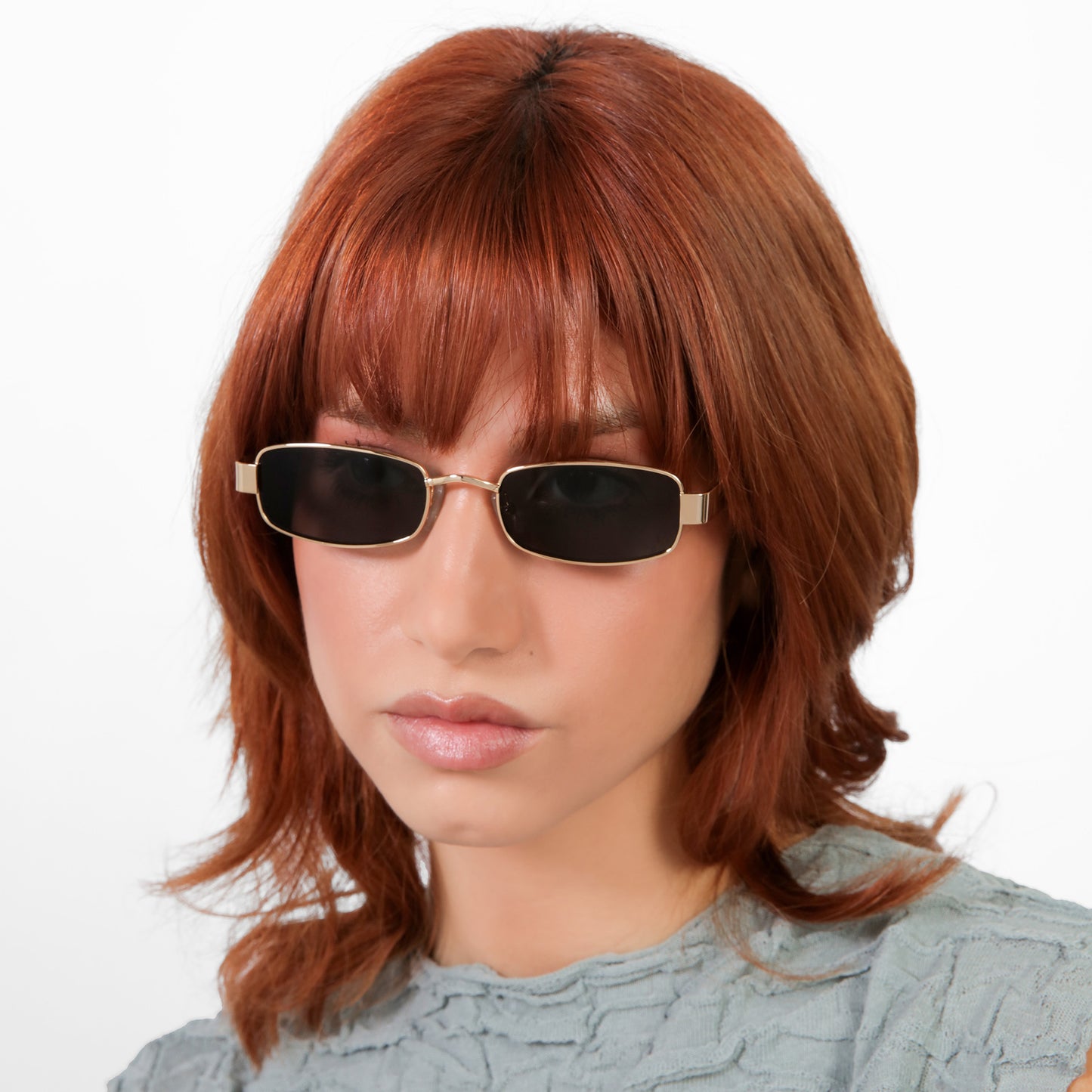 Another angle of model wearing Shores Sunglasses in Gold with Grey lenses