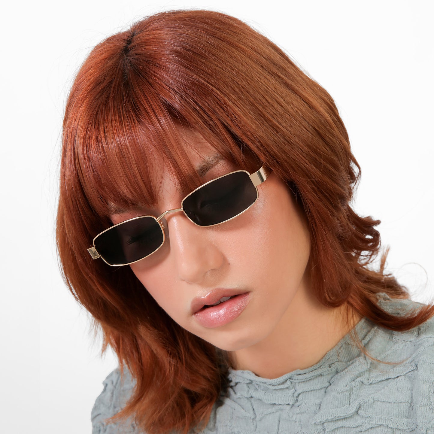 Close-up of model wearing Shores Sunglasses in Gold with Grey lenses
