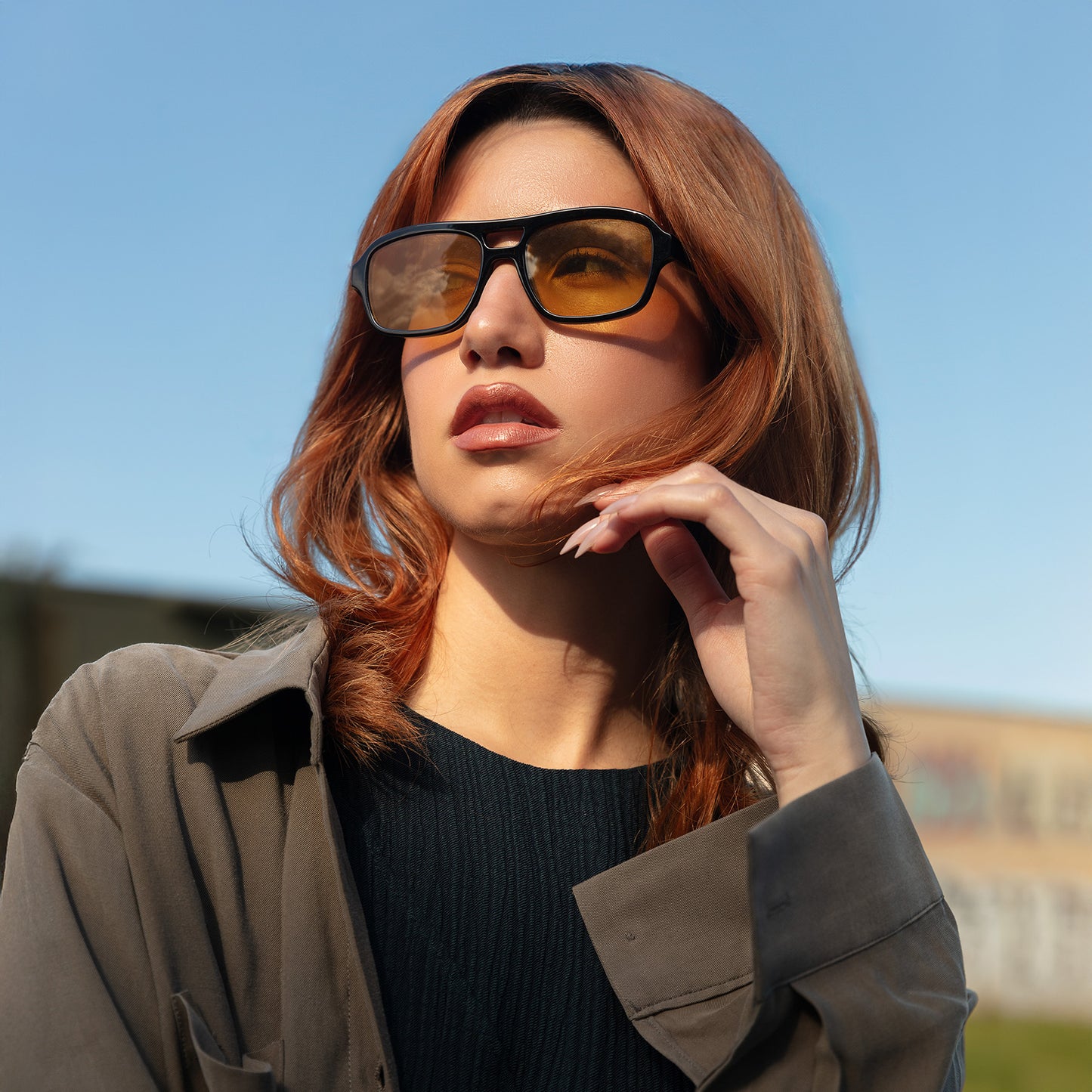 Model wearing Morningside Sunglasses in Black with Yellow lenses near train tracks