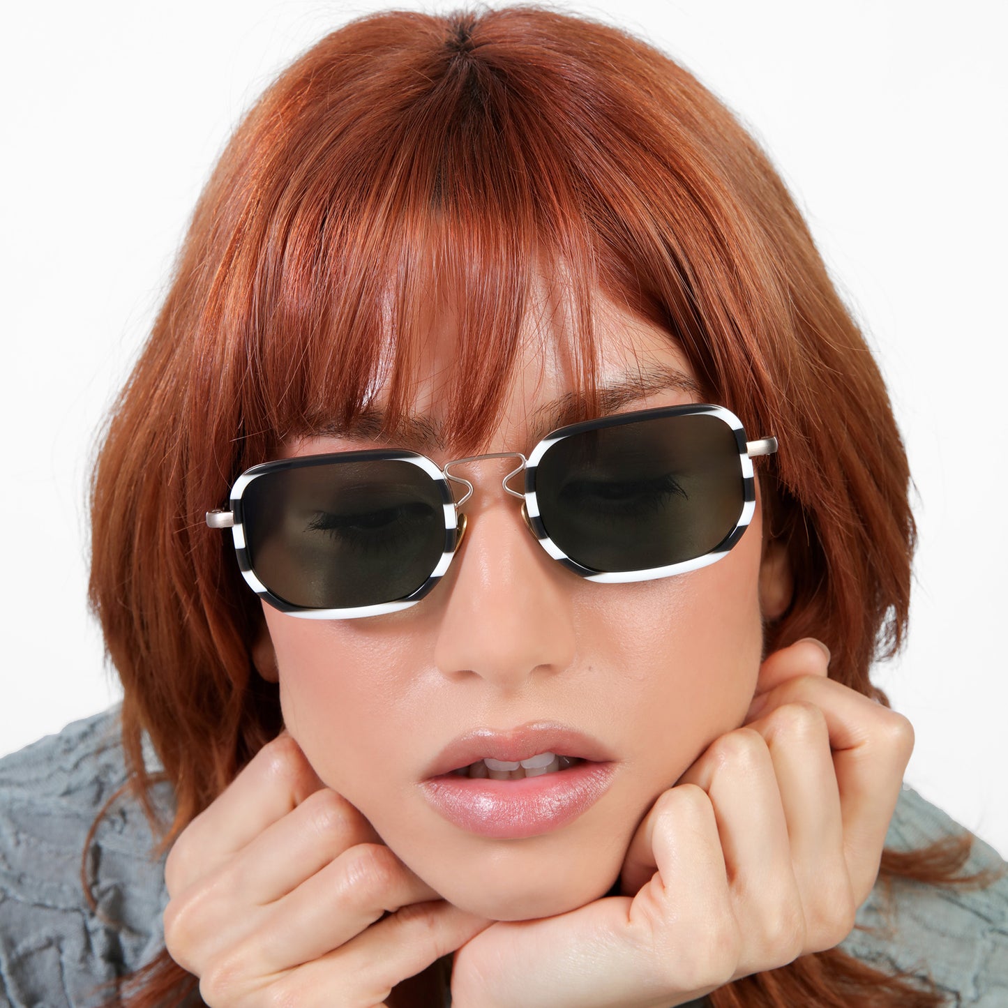 Close up of a model wearing Venetian Sunglasses in Black White Stripes with Olive lenses